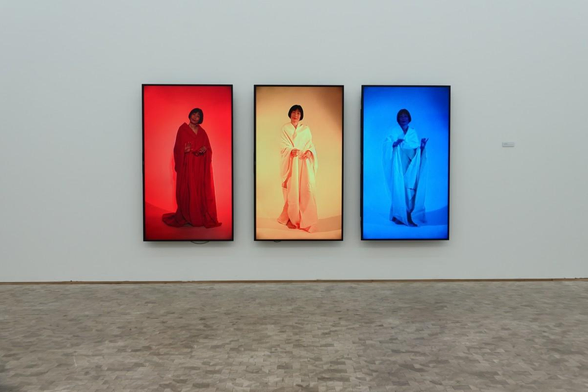 Three screens with different colors and a woman on display