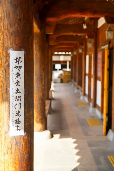 Traditional wooden house pillar with written characters on a poster