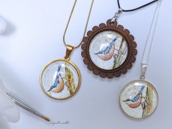 handgemaltes 30mm-Aquarell mit Kleiber-Illustration 30mm groß, 
Gemalt auf rohweißem rauhem Echtbüttenpapier mit Metallic-Effektaquarellfarben und "normalen" Aquarellfarben; unter Glas geschützt
Gefasst wahlweise in runden Anhänger aus Edelstahl, Holz oder Edelstahl.