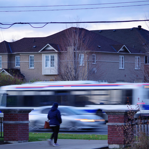A chilly Pedestrian, a blurry Car, and a blurry Brampton Bus no. 14—with a repeating 4—headed in different directions, in a clear residential Thursday street, for a morning commute.