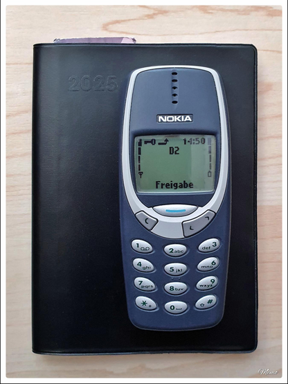 Bildbeschreibung: 
Ein Nokia 3310 liegt auf einem Taschenkalender.