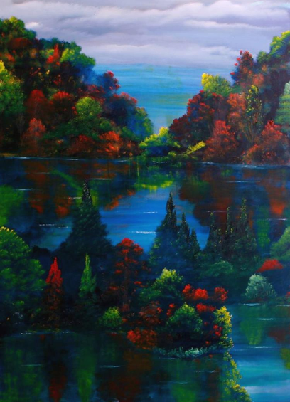 A peaceful yet dramatic scene of heavily forested hillsides steeply sloping up from a lake that weaves through them. The trees are a dark, dense green with some scattered among them of a bright red, orange, and a few yellow as they get their autumn colors. The water is a bright blue and the sky has a couple of layers of greyish clouds.