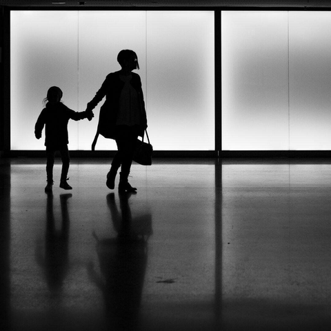 Deux silhouettes sur fond clair qui se donne la main.