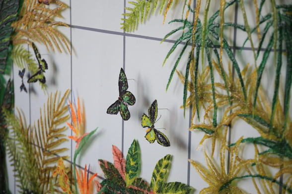 a detail of a patterned and floral wall artwork by Kate Clements made from kiln-fired glass