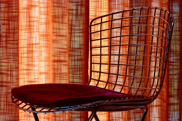A chair in front of a curtain