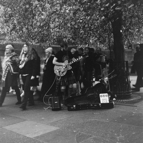 Yashica MAT124G | Cinestill BWXX 250 | Shot at 400 + Med Yellow Filter | Developed in XTOL

A busker playing electric guitar in a kilt.  You can’t tell by the picture but he was nailing one of Gilmour’s licks from Dark Side of the Moon