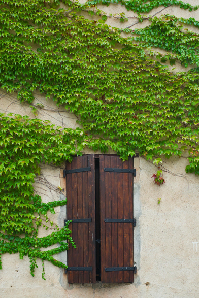 A window with brown wooden shutters.