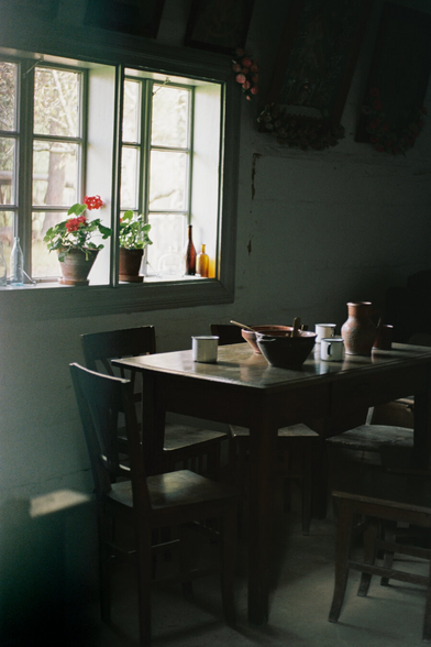 A table with unwashed dishes, light streaming through the window.