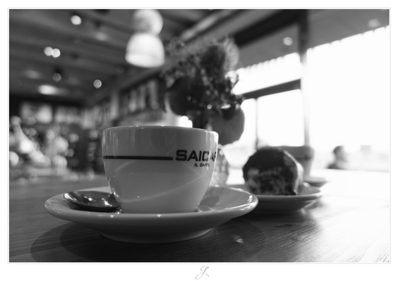 A wooden table with a cup of cappuccino, photographed in close-up slightly above the tabletop. To the right, a small plate with a piece of cake and another cup blur into the blurry, bright background formed by a large window, which is completely blurred by the sunlight shining in from outside. The picture is black and white.

AI disclaimer: Using my work, its meta data, written or derived description to create media with or train AI based systems is prohibited.