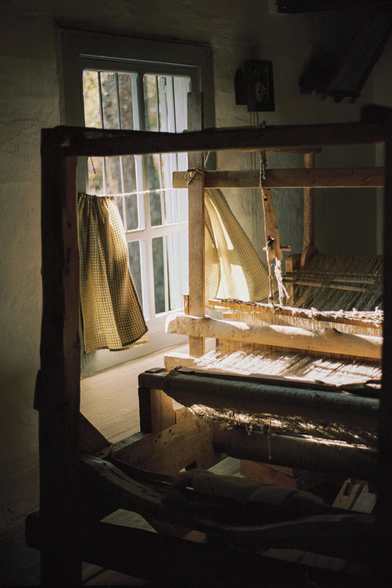 An old cotton machine by the window, lots of light coming into the room.