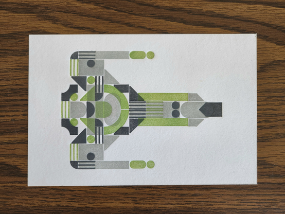 a blocky print of a spaceship in light green, light gray, and dark gray. it's a long-nosed ship with stubby wings and blaster tips