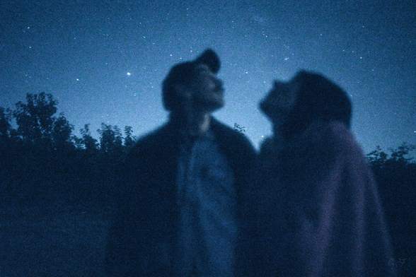 Photo of two people looking at the night sky.