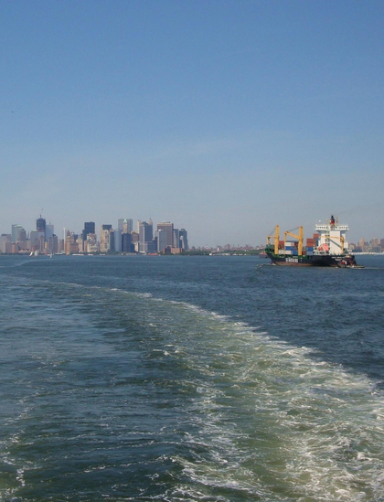 Ein historisches NYC-Foto aus der Zeit, als die Twin Towers bereits zerstört, das One World Trade Center aber noch nicht erbaut war. Ein Containerschiff bei der Anfahrt auf New York City; im Hintergrund die Kulisse von Manhattan.