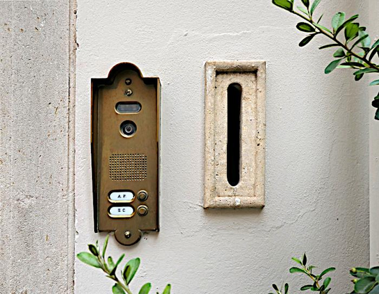 Foto van deurbellen en brievenbus met initialen op de twee naamplaatjes