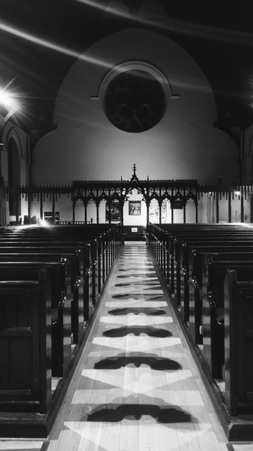 Looking directly up the main aisle between the rows of pees in Christ Church, towards the rear of the church