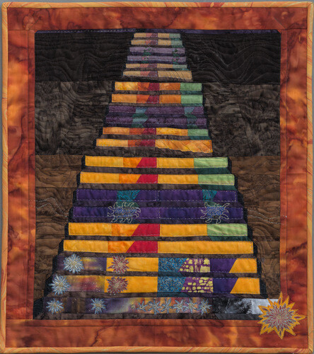 "In the Hall of the Mountain King". Rectangular wall quilt which looks a bit like a step pyramid, or maybe a top-down view of a xylophone. Each row gets progressively bigger and brighter until there are starburst explosions in the last three rows.