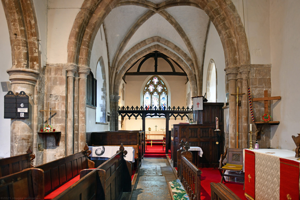 Photo of the interior of the church of St Julian at Buci, looking towards the chancel from the nave. The panelled pulpit is said to be C18. Rood screen said to be late C15, much restored. West Sussex, UK.