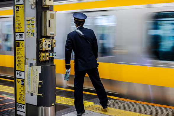 A train platform operator in uniform on duty at Shinjuku station in Tokyo (Japan). Each image features a different posture and gesture of the officer.