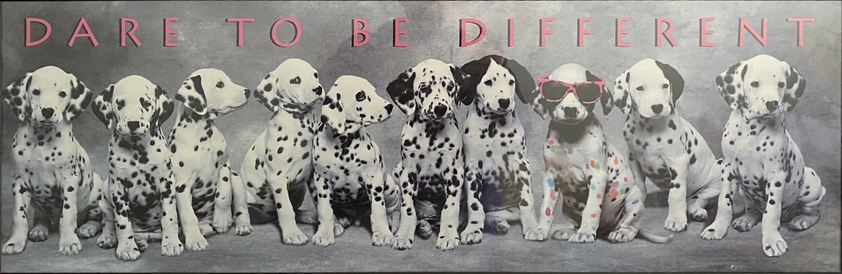 Ten Dalmatian puppies sit in a row. The third puppy from the right has a different pattern of spots and is wearing sunglasses. The words "Dare to be different" is places above the puppies.
