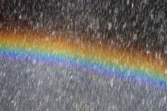 Rainbow behind waterdrops in close up