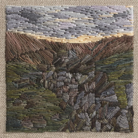 Stitched artwork depicting a dark moorland hillside with a tumble down dry stone wall leading away from the eye. The sun has just set and there is a bright line of sunshine on the horizon beneath grey/purple clouds