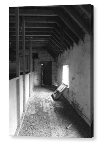 Black and white portrait photograph of an abandoned barn interior.  The image is shown printed upon a block canvas.