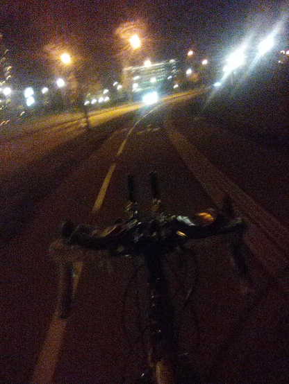 Guidon de vélo type route avec prolongateurs longs montés dessus, piste cyclable, bâtiments et leurs lumières, la nuit.

Si vous êtes non-voyant montrez la photo à des voyants comme un exemple de basse qualité assez terrible :)
Mais ça fonctionne!