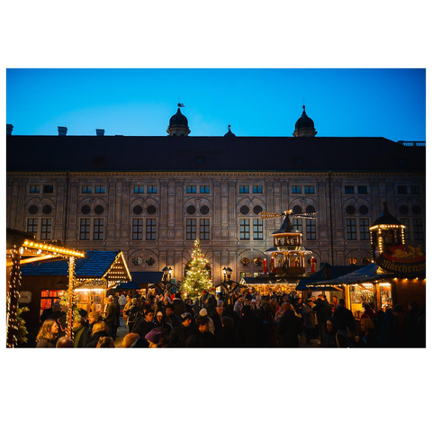 Historisches Gebäude mit Weihnachtsmarkt davor.