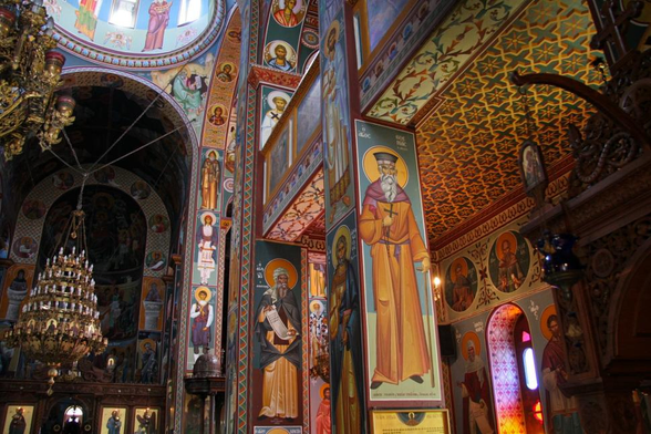The interior of a church rich in colorful Byzantine frescoes of Cretan and Macedonian inspiration.