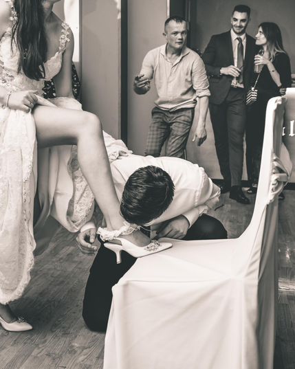 El novio le saca la liga a la novia con la boca.