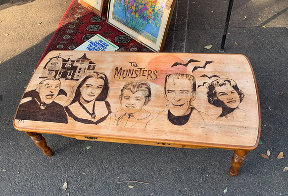 An impressive rendering of The Munsters, carved into the top of a coffee table.