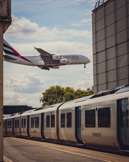 Emirates A380 flying over a Thameslink Class 700 at Gatwick Airport train station