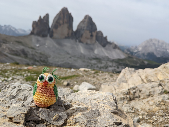 A knitted owl in front of the Tre Cime di Lavaredo
