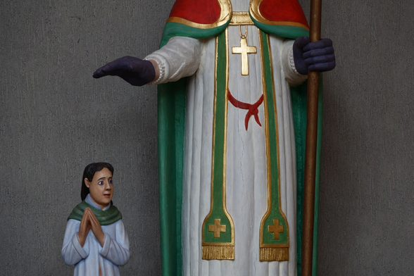 lower part of a statue of a saint protecting a child