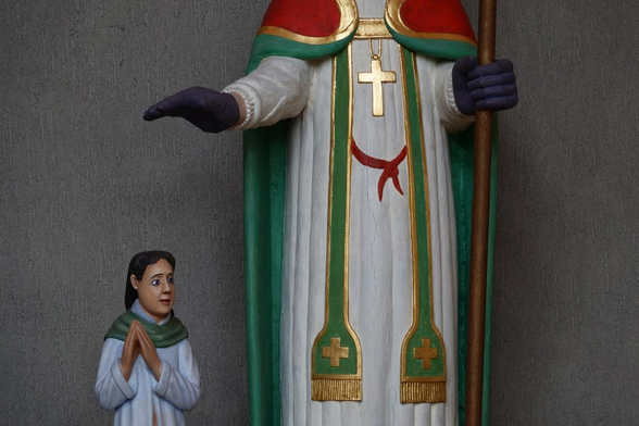 lower part of a statue of a saint protecting a child 