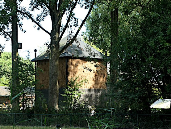 Foto van hooimijt tussen bomen