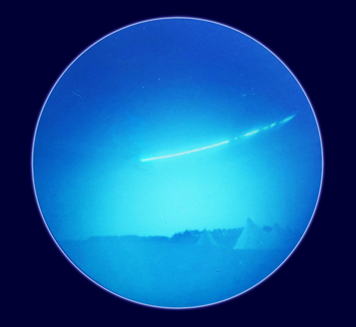 A #SolarCanPuck exposure over part of a day. A single line is visible in the sky. Tents are in the foreground.