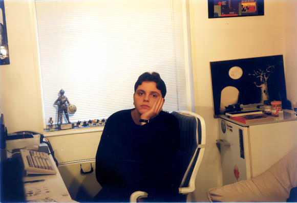 A photograph from 1992 of game developer Metin Seven, surrounded by retro-computing nostalgia.