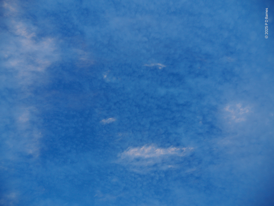 A mix of high and low cloud, streaks and little puffballs, lit varying amounts by as-yet uncoloured dawn light. The darker blue of some clouds contrasts subtly with the blue of the sky and the white of others.