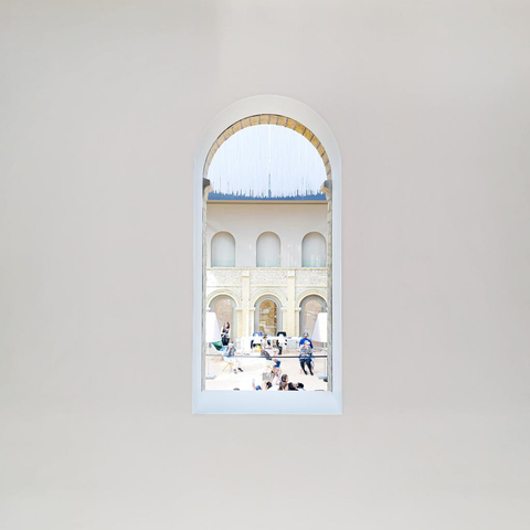 People visible though a hole in a wall in a museum