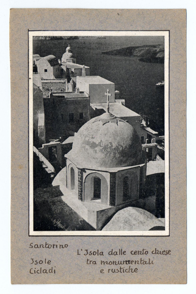 The image features a monochromatic photograph of architectural structures, possibly from an old postcard or historical publication. In the foreground is a prominent domed building with a cross atop its peak, indicative of Christian architecture, likely a church on Santorini in Greece given the text reference to "Santorino" and "3 sole cicladi." The dome's smooth surface reflects light differently across various points, suggesting a possible weather condition or time when captured. Surrounding this central structure are multiple smaller buildings with varied architectural styles: some have arched doorways, others feature simple geometric shapes typical of Cycladic architecture.

The background reveals more of the landscape including additional buildings and possibly an expansive body of water which could be indicative of Santorini's volcanic terrain or its proximity to a harbor. The sky is partly visible at the top right corner, with soft shading that might suggest either dawn or dusk lighting conditions.

Text on the image includes "Santorino," followed by what appears to be Italian phrases referring to sunlight and ancient churches in contrast between monumental and rustic styles ("L'isola dalle cento chiese 3 sole tra monunntentali e rustiche"). The text suggests that this photograph is part of a collection or series highlighting notable structures on the Greek island.
