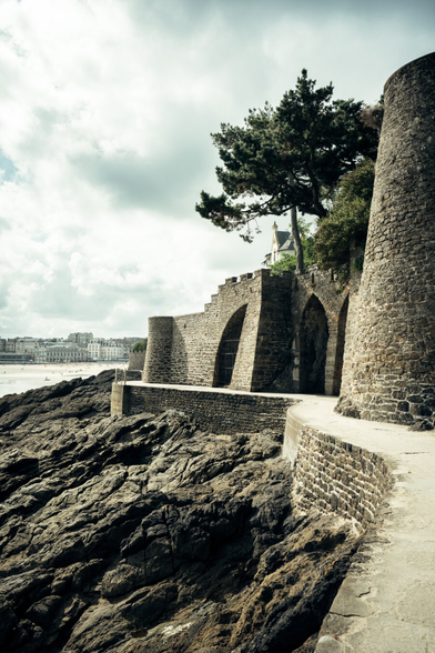 Coast with fortifications and a city in the background