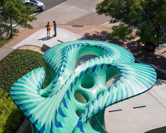 an aerial view of a contemporary, teal-colored pavilion designed by Marc Fornes/THEVERYMANY in a public square in Knoxville, Tennessee