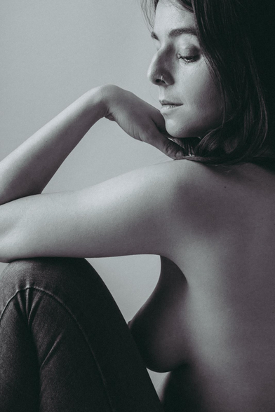 Chica morena sentada en el suelo.