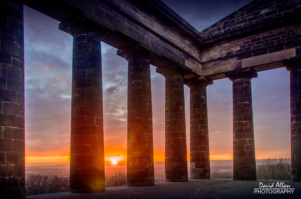 A November sunset at an iconic landmark of NE England. The sun is captured setting between the columns of Penshaw Monument, completed in 1845 (funded by public subscription) to commemorate John Lambton, 1st Earl of Durham (1792–1840), Governor-General of British North America and author of the Durham Report on the future governance of the American territories.
Inspired by the Temple of Hephaestus in Athens and the care of the National Trust since 1939, it is a Grade I listed structure.