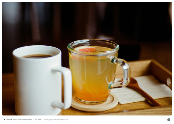 테이블 위의 나무 트레이 위로 자몽 유자차와 아메리카노 커피가 나란히 올려져 있는 모습.