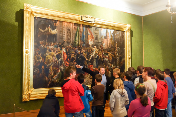 Famous painting by Jan Matejko of the declaration of the second-oldest constitution in the world, 3 May 1791, Polish-Lithuanian Commonwealth, as being described (with actions) to a school group.  The painting is housed in the castle seen in the picture.