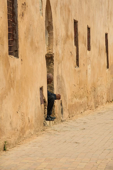 Man sitting contemplating on his door step in Morocco