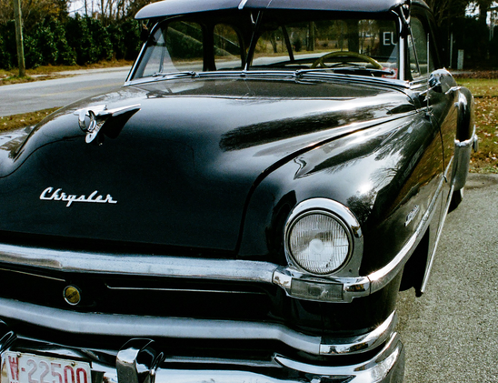 A black 1951 Chrysler automobile from the front and slightly down one side.