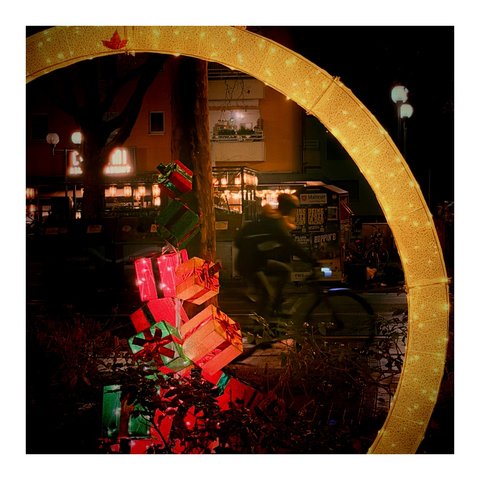 Ein großer goldgelber Reif, im Zentrum eine Geschenkepyramide im abendlichen Laternenlicht